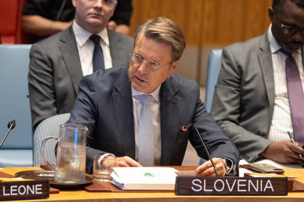 Slovenian Ambassador Žbogar sitting at the table in the UN Security Council Chamber, speaking and surrounded by other people