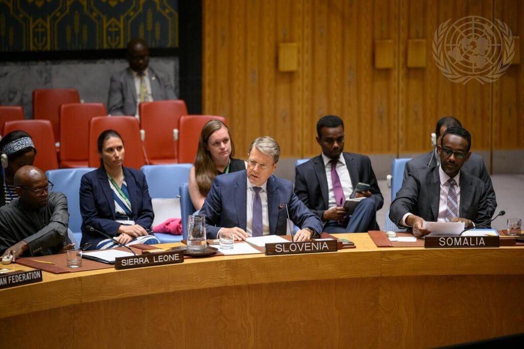 Slovenian Ambassador Žbogar sitting at the table in the UN Security Council Chamber, speaking and surrounded by other people