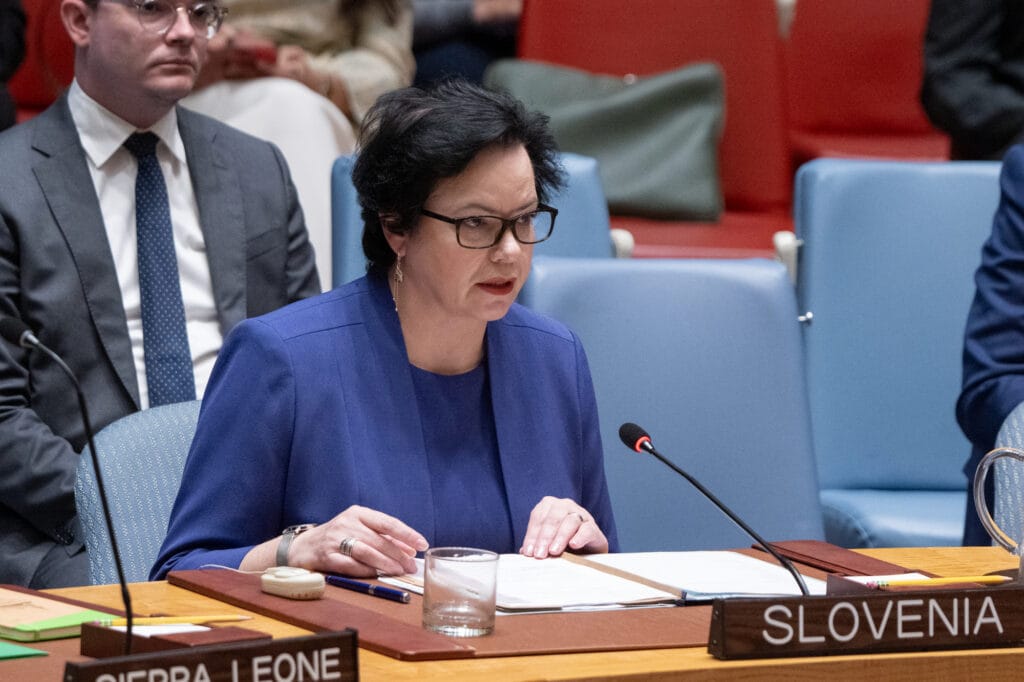 Ms. Ondina Blokar Drobič sitting at a table and delivering Slovenian statement, surrounded by other people