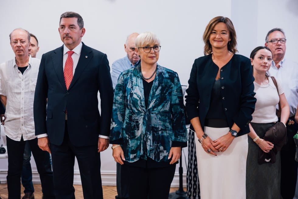 Predsednica Nataša Pirc Musar, predsedničin soprog dr. Aleš Musar ter ministrica za zunanje in evropske zadeve Tanja Fajon stojijo in se nastavljajo fotografskemu objektivu. Okrog njih drugi ljudje.  