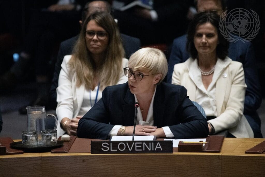 Predsednica RS sedi pred mikrofonom in bere izjavo v Varnostnem svetu ZN. Za njo sedijo drugi ljudje. 