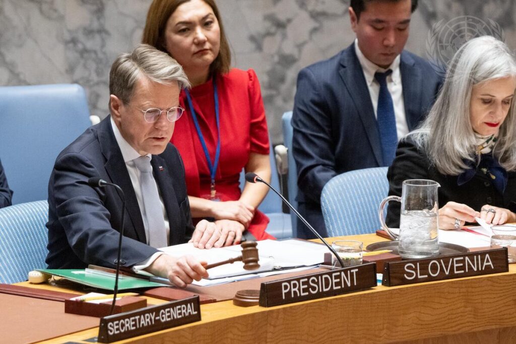 Slovenian Ambassador Žbogar sitting at the table in the UN Security Council Chamber, speaking and surrounded by other people.